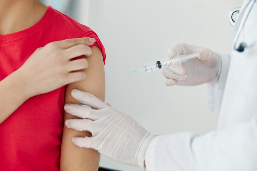 the doctor puts an injection into the patient's hand close-up vaccination